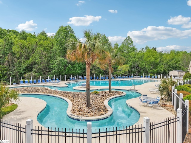 community pool featuring fence and a patio