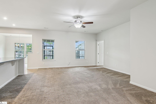 empty room with baseboards, recessed lighting, ceiling fan with notable chandelier, and carpet flooring