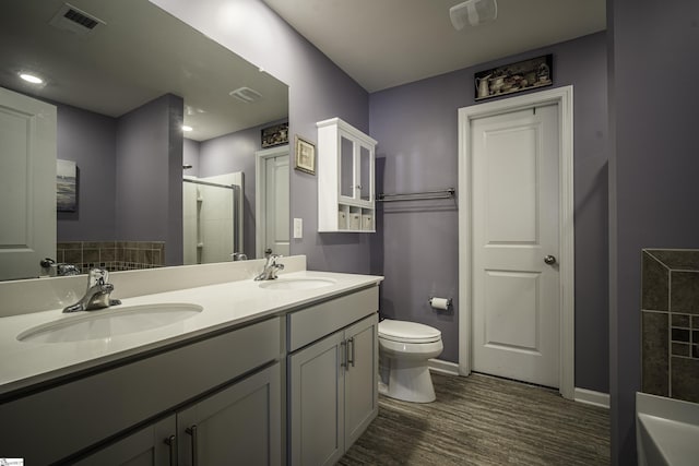 full bathroom featuring visible vents, wood finished floors, a sink, and a shower stall