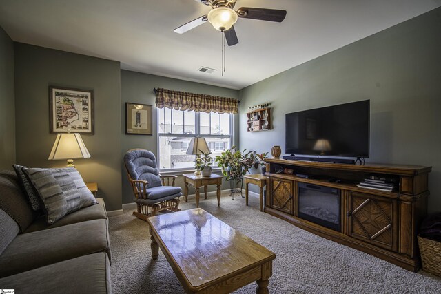 living area with baseboards, a ceiling fan, visible vents, and carpet floors