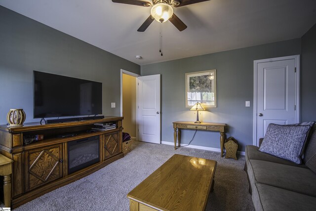 carpeted living room featuring baseboards and ceiling fan