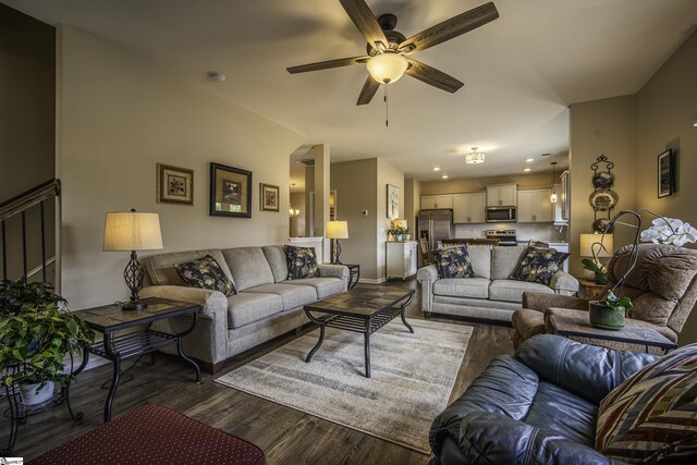 living area with dark wood-style flooring, a ceiling fan, and baseboards