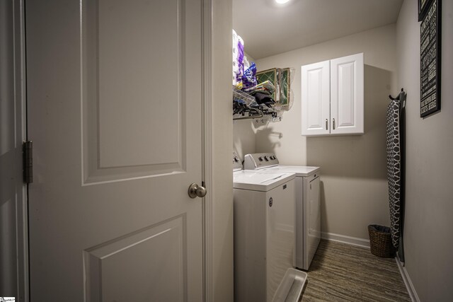 washroom with cabinet space, baseboards, and separate washer and dryer