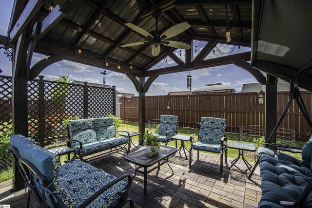 view of patio with an outdoor living space, a fenced backyard, a ceiling fan, and a gazebo