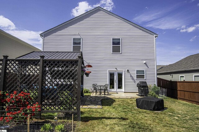 back of property featuring fence, a lawn, and a patio