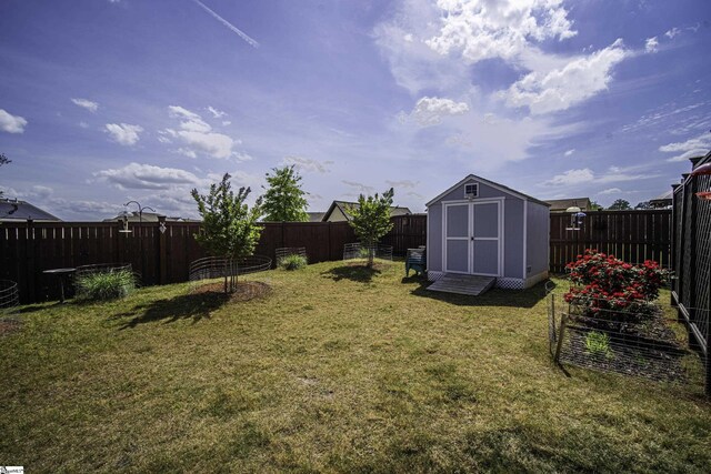 view of yard featuring a fenced backyard, an outbuilding, and a shed
