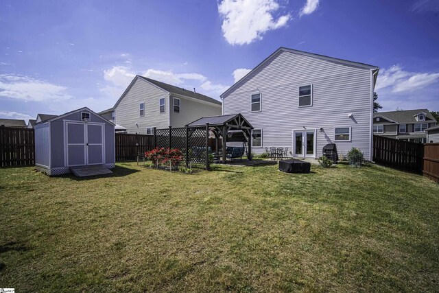 rear view of house featuring a gazebo, a lawn, a shed, and a fenced backyard