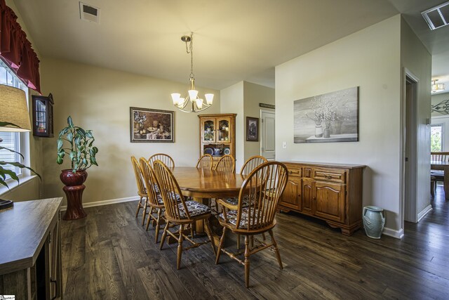 dining room featuring dark wood-type flooring, visible vents, baseboards, and an inviting chandelier