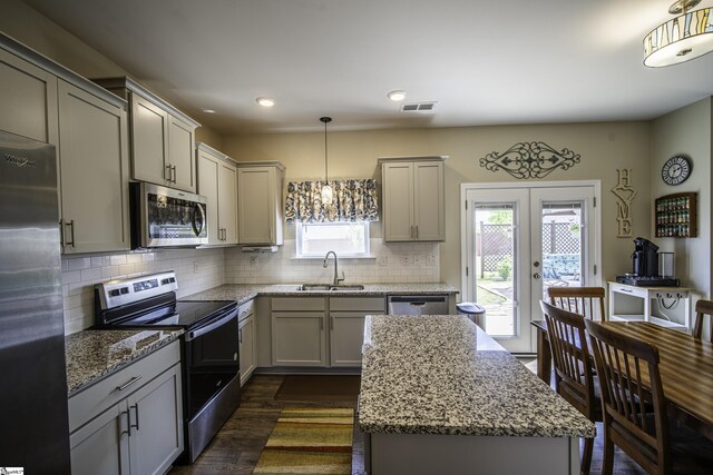kitchen featuring stainless steel appliances, visible vents, a sink, gray cabinetry, and tasteful backsplash