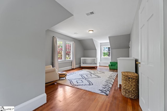 bedroom featuring hardwood / wood-style flooring, baseboards, lofted ceiling, and visible vents