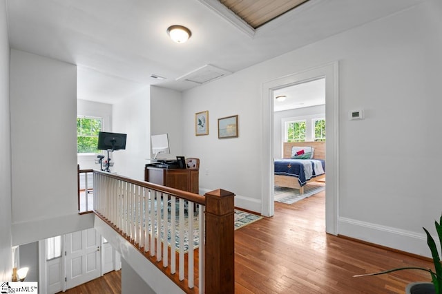 interior space featuring attic access, baseboards, visible vents, an upstairs landing, and hardwood / wood-style floors