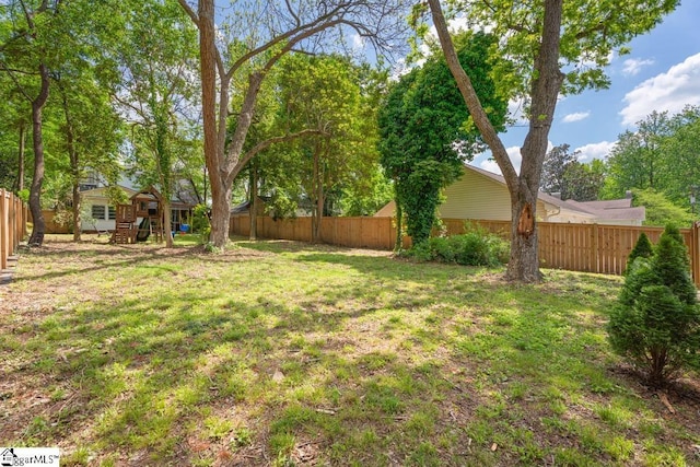 view of yard with a fenced backyard and a playground