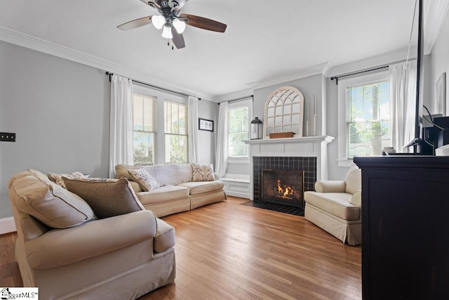 living room featuring wood finished floors, a wealth of natural light, crown molding, and ceiling fan