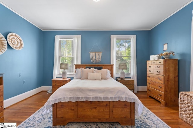 bedroom with crown molding, baseboards, and multiple windows