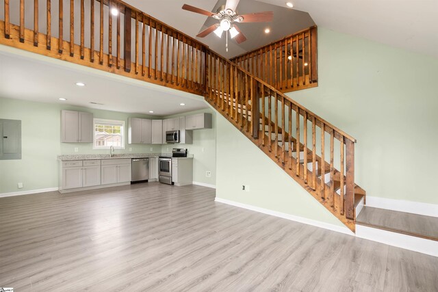 381 Deer Farm Pond Ln, Fair Play, SC 29643 - unfurnished living room with a sink, stairs, a towering ceiling, light wood-style flooring, and baseboards