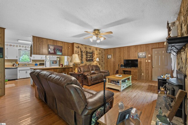 222 Mason Dr, Inman, SC 29349 - living room with wood walls, a textured ceiling, light wood-style floors, and ceiling fan