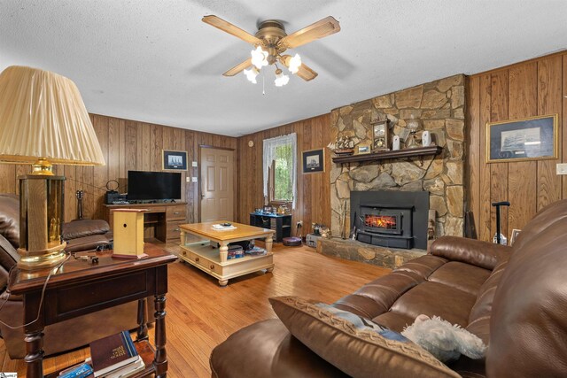 222 Mason Dr, Inman, SC 29349 - living room featuring a stone fireplace, a ceiling fan, wood finished floors, and wooden walls