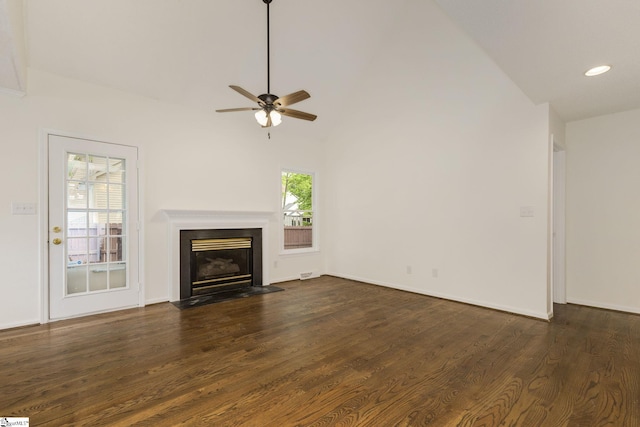 unfurnished living room with a fireplace with flush hearth, vaulted ceiling, ceiling fan, and dark wood-style flooring