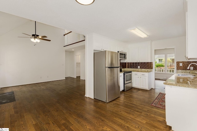 kitchen with decorative backsplash, dark wood-style flooring, stainless steel appliances, and a sink