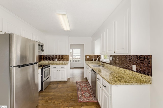 kitchen with white cabinets, appliances with stainless steel finishes, a sink, and dark wood-style floors