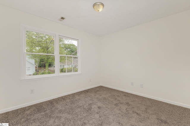 spare room featuring baseboards, carpet flooring, and visible vents