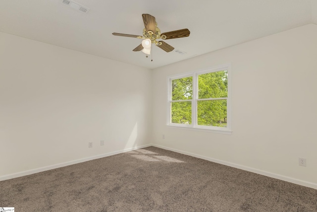 carpeted empty room featuring visible vents, a ceiling fan, and baseboards
