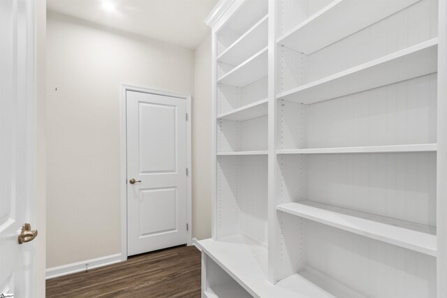 mudroom with dark wood finished floors and baseboards
