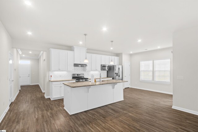 kitchen featuring appliances with stainless steel finishes, baseboards, and under cabinet range hood