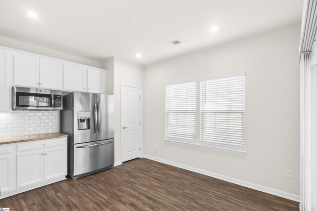 kitchen featuring dark wood-type flooring, tasteful backsplash, baseboards, and stainless steel appliances
