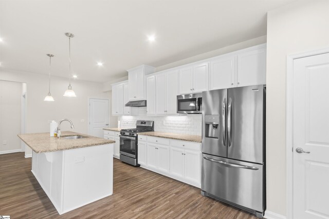 kitchen featuring stainless steel appliances, a sink, white cabinetry, decorative backsplash, and under cabinet range hood