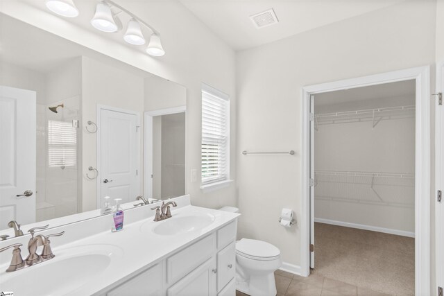 bathroom with a walk in shower, tile patterned floors, a sink, and visible vents