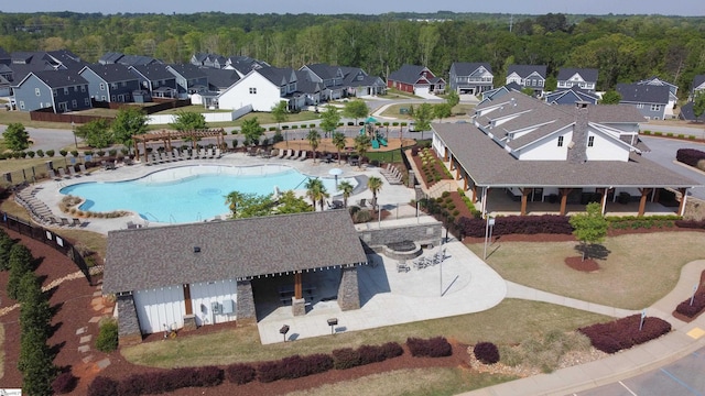 drone / aerial view featuring a residential view and a view of trees