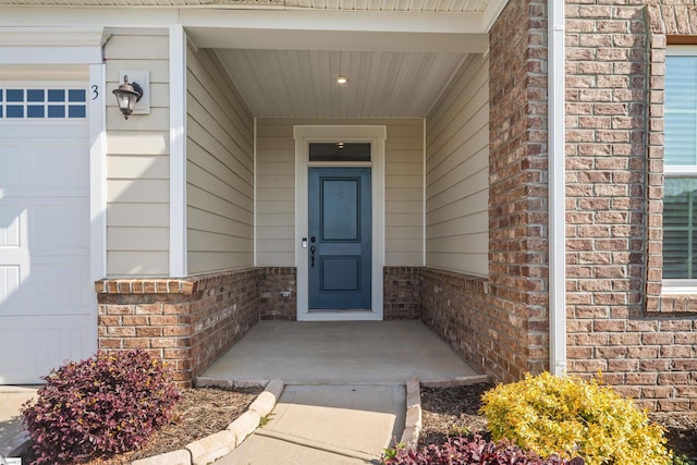 doorway to property featuring brick siding and a porch