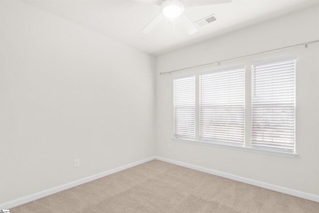 empty room with ceiling fan, visible vents, and light carpet