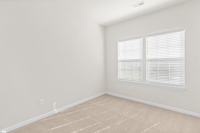 carpeted spare room with baseboards and visible vents
