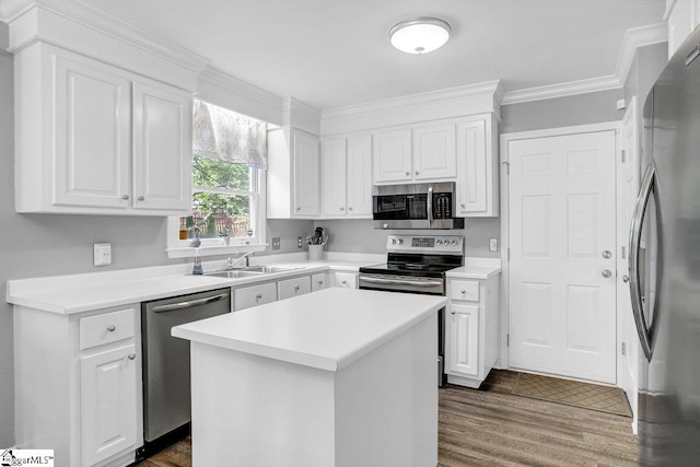 kitchen featuring white cabinets, stainless steel appliances, a sink, and crown molding