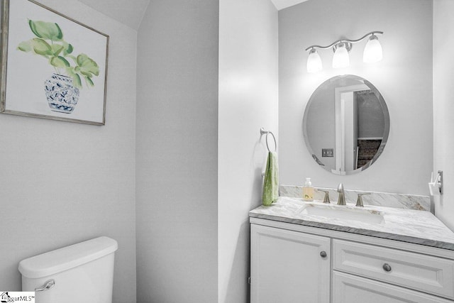 half bathroom with toilet and vanity