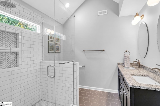 bathroom featuring tile patterned floors, visible vents, a sink, and a stall shower