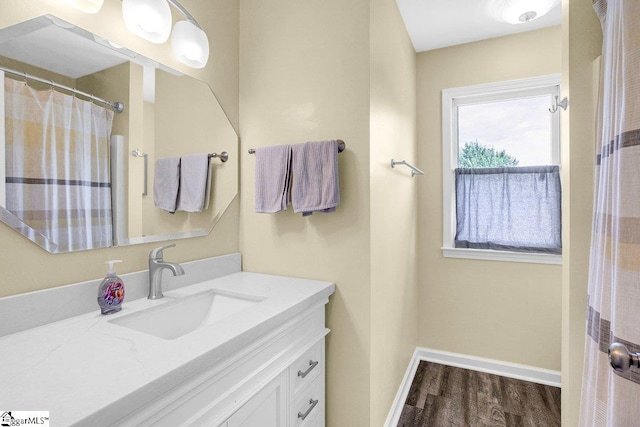 bathroom featuring baseboards, vanity, and wood finished floors