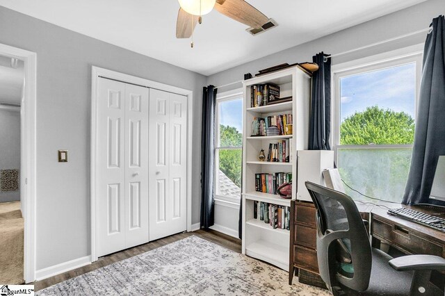 office area with baseboards, a ceiling fan, wood finished floors, and visible vents