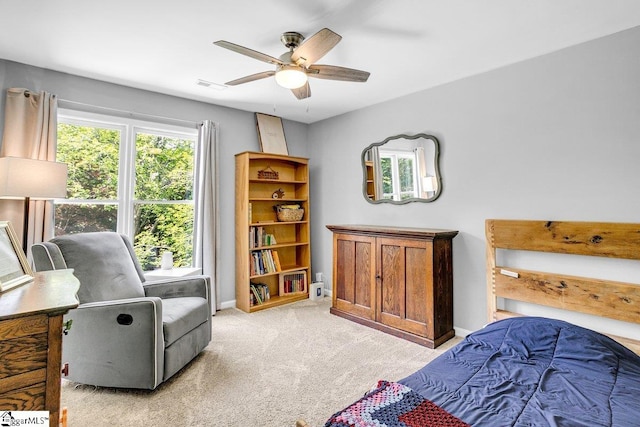 bedroom with baseboards, a ceiling fan, visible vents, and light colored carpet