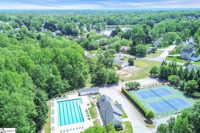 birds eye view of property with a wooded view and a water view