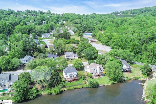 bird's eye view featuring a wooded view, a residential view, and a water view