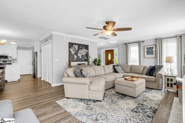 living area with wood finished floors, visible vents, and ceiling fan
