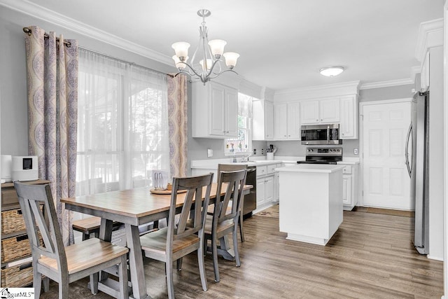 dining area with a chandelier, wood finished floors, and crown molding