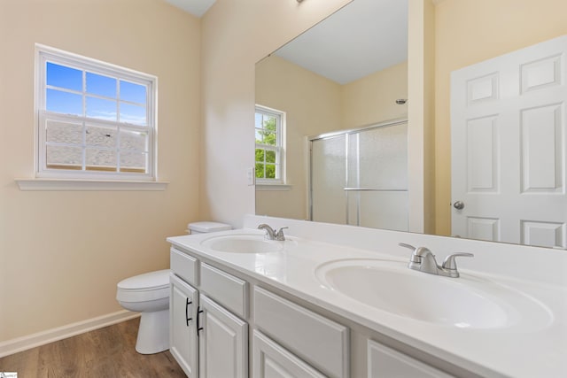 full bath with a shower stall, wood finished floors, baseboards, and a sink