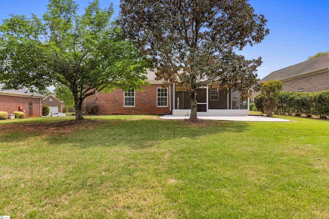 rear view of house with brick siding, a sunroom, and a yard