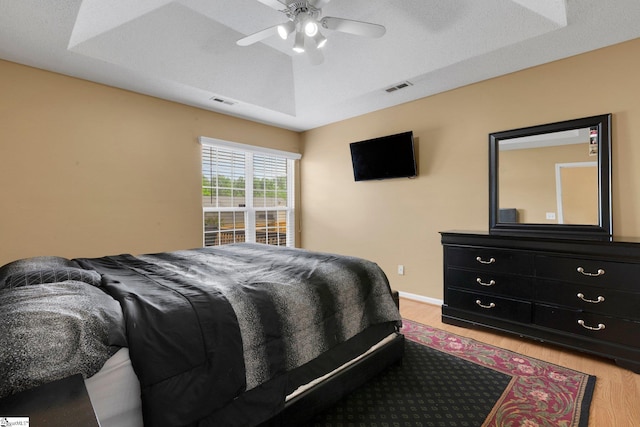 bedroom featuring visible vents, light wood finished floors, and a ceiling fan