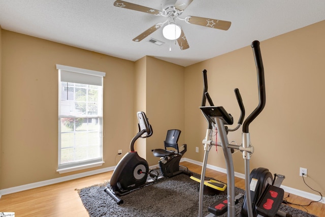 exercise area with ceiling fan, wood finished floors, and visible vents