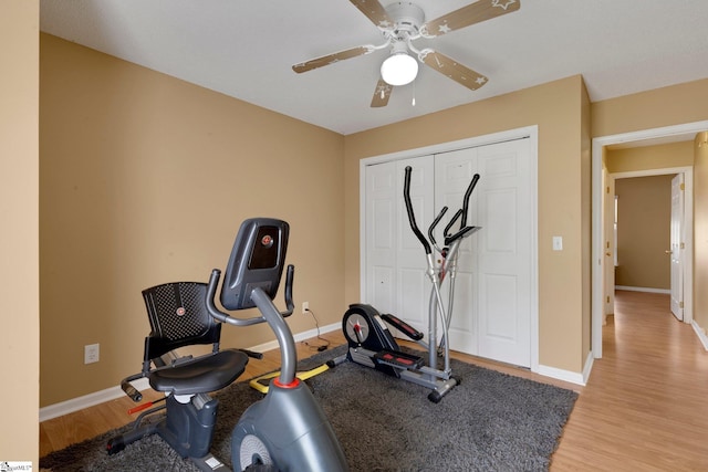 exercise room with ceiling fan, baseboards, and light wood finished floors